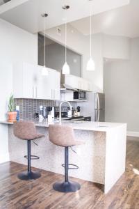 una cucina con bancone e 2 sgabelli da bar di Downtown Luxury 1BR Loft a Milwaukee