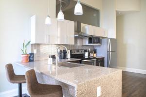 una cucina con ampia isola e armadi bianchi di Downtown Luxury 1BR Loft a Milwaukee