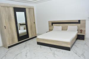 a bedroom with a large bed and a mirror at Beautiful Modern Villa in Mbour +16 photos
