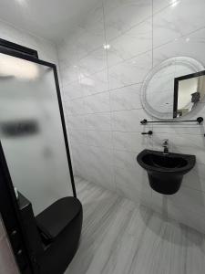 a bathroom with a black toilet and a mirror at Beautiful Modern Villa in Mbour