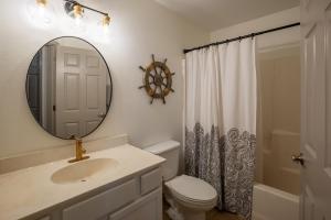 a bathroom with a sink and a mirror and a toilet at AK Getaway Too ,where the waves the shore and worries melt away. in Port Aransas +9 photos