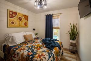 a bedroom with a bed with a colorful comforter and a window at AK Getaway Too ,where the waves the shore and worries melt away. in Port Aransas
