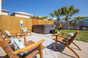a patio with two chairs and a fire place at AK Getaway Too ,where the waves the shore and worries melt away. in Port Aransas