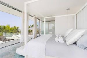 ein weißes Schlafzimmer mit einem großen Bett und großen Fenstern in der Unterkunft Villa Palm Abama Golf in Playa de San Juan + 61 Fotos