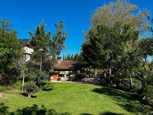 una casa con un patio con árboles y césped en Bosco D'Olmi Country House, en SantʼAndrea del Garigliano