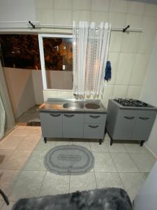 een keuken met een spoelbak en een fornuis bij AP completo a 5 min da Praia, Itapema-SC in Itapema