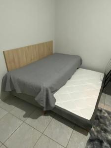 een bed in een kamer naast een muur bij AP completo a 5 min da Praia, Itapema-SC in Itapema +3 foto's