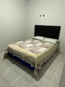 een bed met een quilt erop in een kamer bij AP completo a 5 min da Praia, Itapema-SC in Itapema