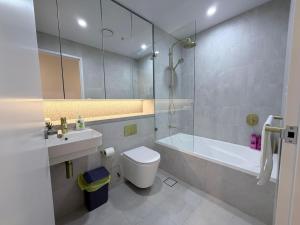 a bathroom with a toilet and a sink and a tub at Cosy Convenience 2BR APT in Castle Hill in Castle Hill +15 photos