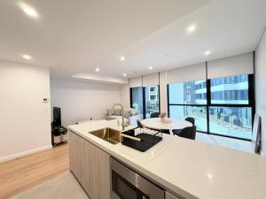 a kitchen and living room with a table and a counter at Cosy Convenience 2BR APT in Castle Hill in Castle Hill