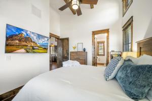 a bedroom with a white bed and a painting on the wall at Sip Sip Hooray at Eagles Nest in Elk Park +42 photos