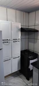 a kitchen with two white refrigerators and a stove at Kitnet in Itaparica Town