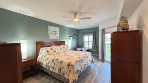 a bedroom with a bed and a ceiling fan at Seashell Escape in New Smyrna Beach +92 photos