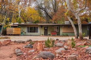 a green house with a red chair in front of it at 18 Creekside Retreat in Sedona