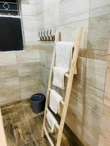 een handdoekenrek in een douche met handdoeken bij Canvas Lofts 2 – Famona duplex 2-bed - 2311 in Bulawayo
