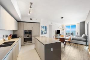 eine Küche und ein Wohnzimmer mit einer Couch und einem Tisch in der Unterkunft Lyfe Resort Oceanfront Luxury Apartment - Exclusive Stay in Hollywood Beach in Hollywood