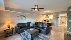 a living room with a couch and a ceiling fan at Seashell Escape in New Smyrna Beach