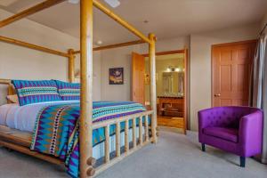 a bedroom with a wooden bed and a purple chair at Adobe Hacienda - Baja Suite in Oak Creek