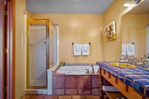 a bathroom with a tub and a shower and a sink at Adobe Hacienda - Baja Suite in Oak Creek