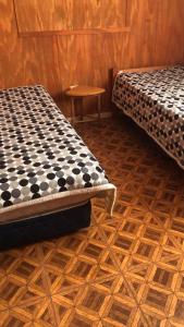 a room with two beds and a wooden floor at Cabañas Mami Kiki in Panguipulli