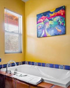 a bathroom with a tub and a painting on the wall at Adobe Hacienda- Sedona Suite in Oak Creek
