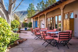 a patio with chairs and tables and a building at Adobe Hacienda - Anasazi Suite in Oak Creek