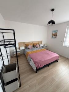 PlesnoisにあるMaison cosy entre Metz, Amnéville et Luxembourgのベッドルーム1室(ピンクの毛布付きのベッド1台付)