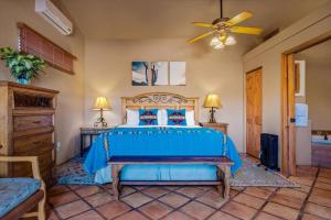 Schlafzimmer mit einem blauen Bett und einem Deckenventilator in der Unterkunft La Casita at Adobe Hacienda in Oak Creek