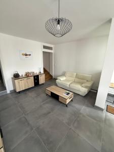 PlesnoisにあるMaison cosy entre Metz, Amnéville et Luxembourgのソファとコーヒーテーブルのあるリビングルーム