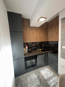 a kitchen with stainless steel appliances and wooden cabinets at UrbanNest Aerodrom in Skopje +22 photos