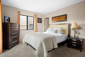 ein Schlafzimmer mit einem Bett, einer Kommode und einem Fenster in der Unterkunft Supai- Adobe Village condo - 2 bedroom in Oak Creek