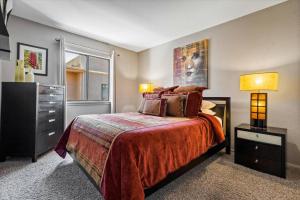 ein Schlafzimmer mit einem Bett mit zwei Lampen und einer Kommode in der Unterkunft Toroweap - Adobe Village condo - 2 bedroom in Oak Creek