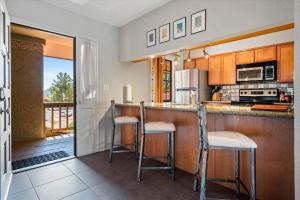 eine Küche mit einer Bar mit zwei Hockern in der Unterkunft Toroweap - Adobe Village condo - 2 bedroom in Oak Creek