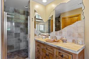 a bathroom with a sink with a heart shaped mirror at Adobe Village Studio Suite- Sundance in Oak Creek