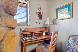 a desk in a room with a chair and a lamp at Adobe Village Studio Suite- Sundance in Oak Creek