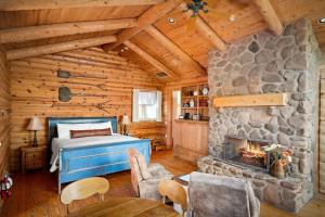 Schlafzimmer mit einem Bett und einem Steinkamin in der Unterkunft Adobe Village Villa with Private Patio- Wilderness in Oak Creek