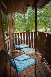 two chairs and a table on the porch of a cabin at MORNING GLORY - Cabin for 2 in Oak Creek in Indian Gardens