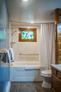 een badkamer met een bad, een toilet en een raam bij Rustic Cabin for 2 in Oak Creek Cabin - WILD ROSE in Indian Gardens
