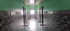 a hallway of a building with tile walls and a door at Zeromiles Green Park in Digha