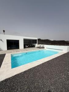 a swimming pool in front of a white house at Casa Jable Mozaga in Mozaga