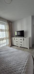 a bedroom with a bed and a flat screen tv at Szabo Georgiana in Alba Iulia