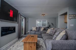 un soggiorno con un divano e una TV di 3BR 2BTH Waterfront Vacation Rental on Riverwalk to Downtown McHenry with Pier a McHenry