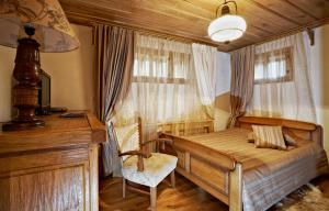 een slaapkamer met een bed, een bureau en een raam bij Радева къща Жеравна in Zheravna