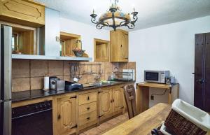 een keuken met houten kasten en een kroonluchter bij Радева къща Жеравна in Zheravna +7 foto's