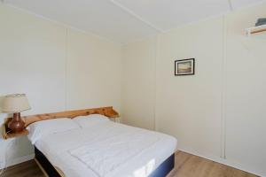 un letto in una camera con pareti bianche di 2-Bedroom Cottage #2 - Shortleaf Pine a Gravenhurst