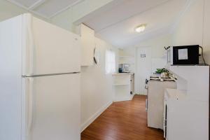 una cucina con elettrodomestici bianchi e frigorifero di 2-Bedroom Cottage #2 - Shortleaf Pine a Gravenhurst