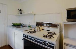 una cucina con piano cottura e bollitore per il tè di 2-Bedroom Cottage #2 - Shortleaf Pine a Gravenhurst Altre 16 foto