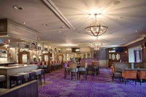 a restaurant with a bar and tables and chairs at Woodford Dolmen Hotel Carlow in Carlow