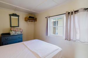 una camera da letto con un letto bianco e una finestra di 2-Bedroom Cottage #3 - Sugar Pine a Gravenhurst Altre 2 foto