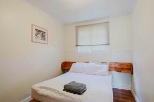 a bedroom with a bed with white sheets and a window at 2-Bedroom Cottage #5 - Lodgepole Pine in Gravenhurst